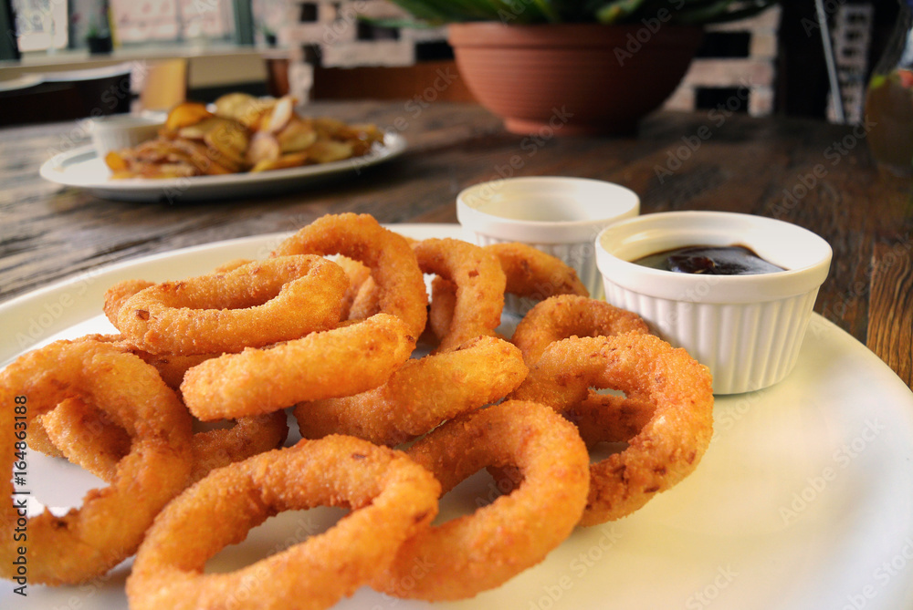 Fried Onion Rings and sauces on wooden table