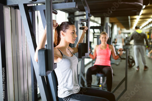 Young women exercising on machine in gym