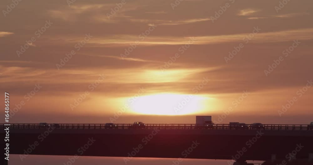 Slow motion, cars and trucks drive over bridge at sunset Slow motion, cars and trucks drive over bridge at sunset