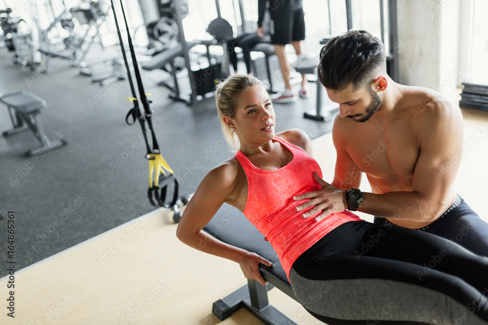 Young beautiful woman working exercises with trainer