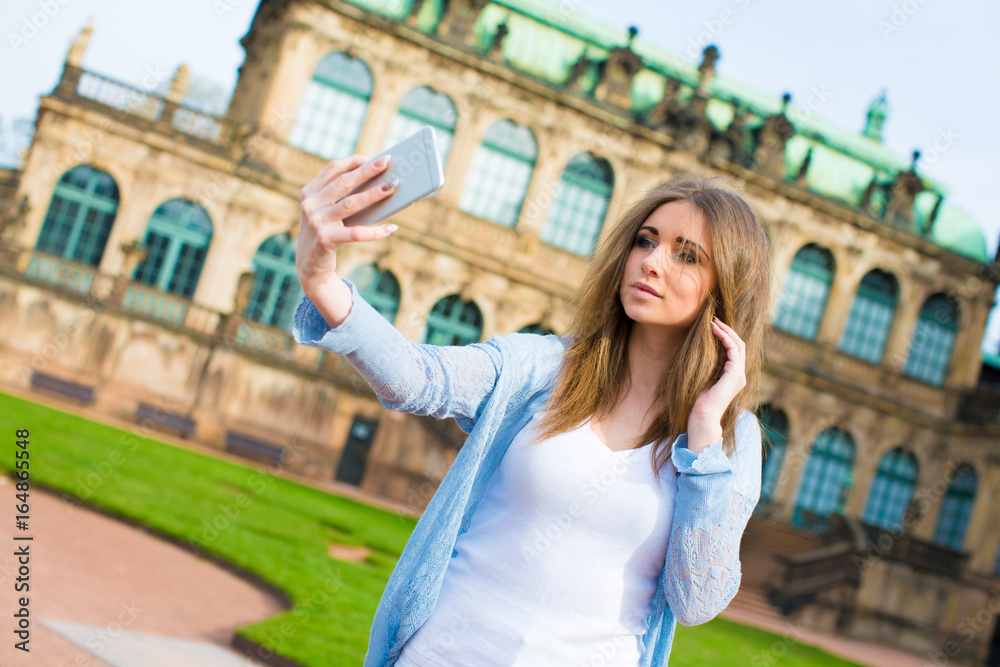 Girl makes photos shots of european city Dresden and selfie of background old German town