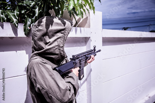 Billede på lærred Gunner terrorists half face and eyes contact with masked and machine gun or rifles sniper shooting are his weapon in Ambush