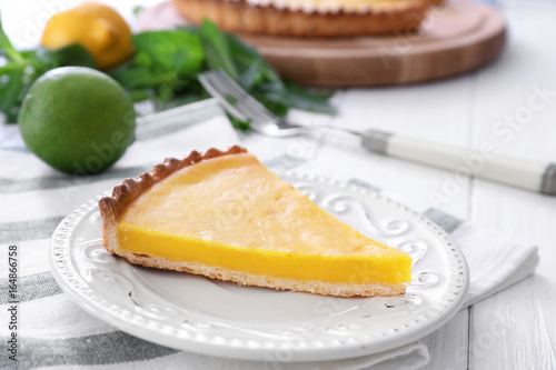 Plate with delicious lemon pie on table, closeup