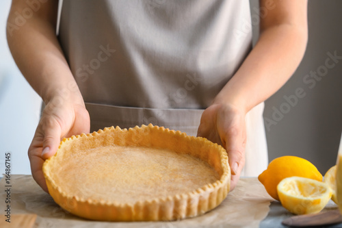 Woman cooking lemon pie in kitchen, closeup