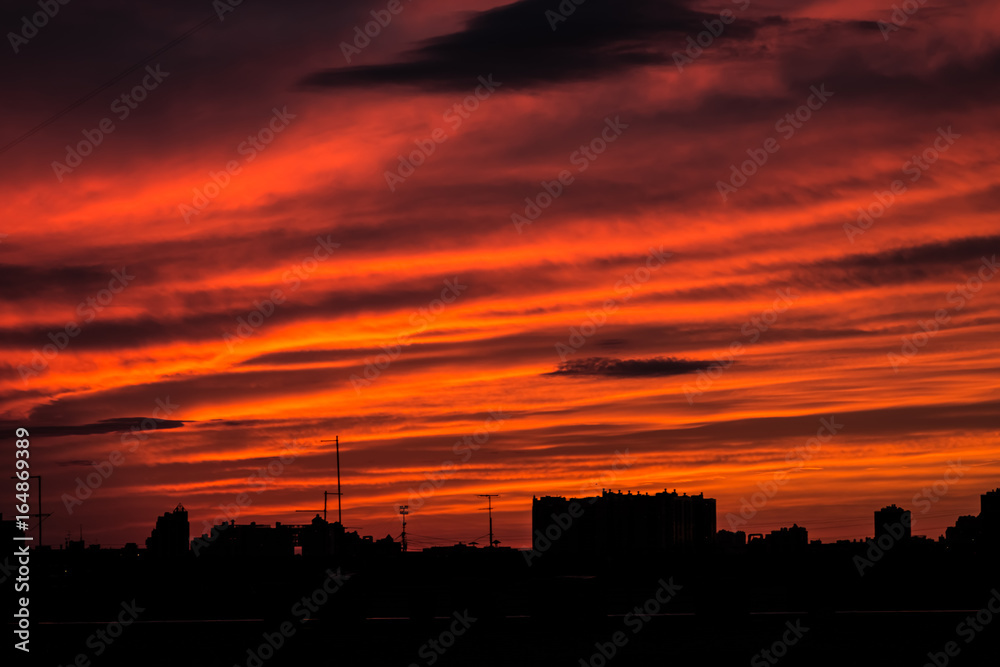 Urban silhouette city skyline in stunning red orange sunset / sunrise.