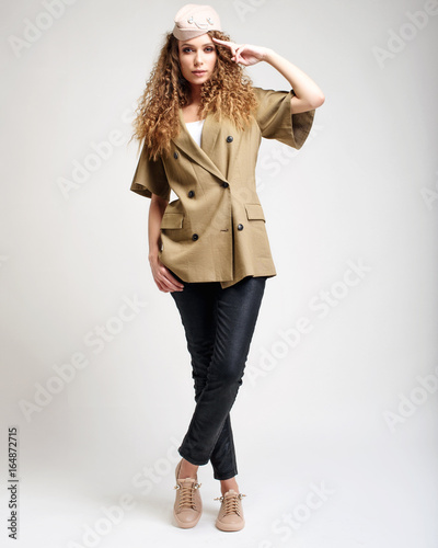 Portrait of a smilling brunette woman over white background. Fashion lookbook.