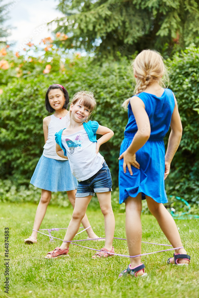 Fototapeta premium Mädchen spielen ein Hüpfspiel im Garten