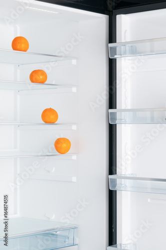 Open fridge with ripe tangerines
