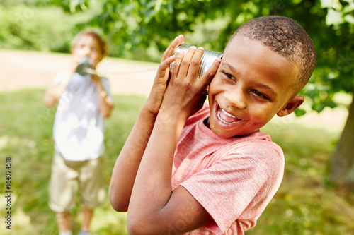 Afrikanischer Junge hat Spaß am Dosentelefon photo