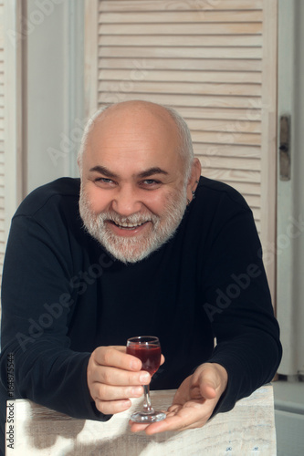 Pensioner smiling with glass of wine