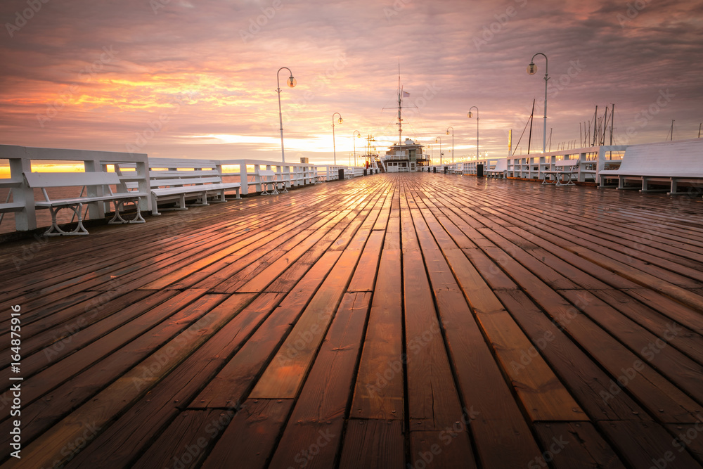 The first rays of the sun warms the wet boards of the pier in Sopot. Poland. The first rays of the sun warms the wet boards of the pier in Sopot. Poland.