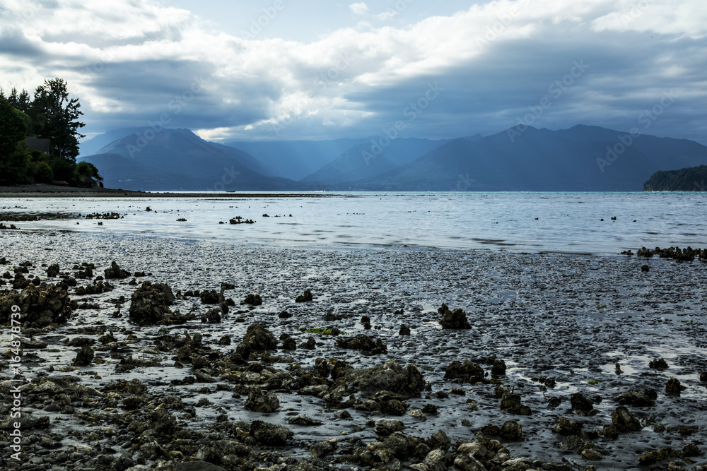 clouds parting over an ocean bay