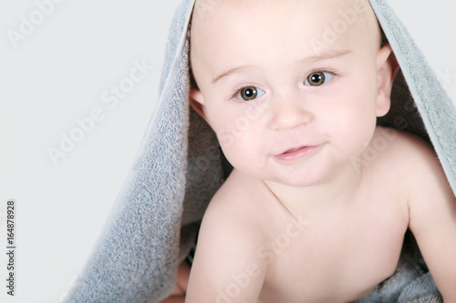 One year old baby lying with towel