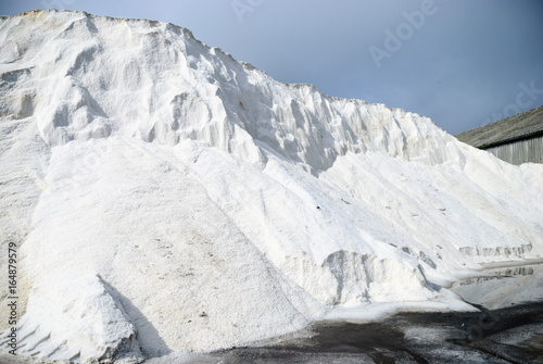 Large pile of rock salt (with salt leaching out) for gritting roads in icy conditions during winter. photo