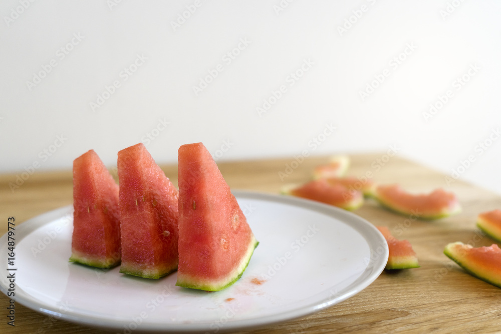 selective focus Slices of watermelon in white plate on wooden table, summer fruit