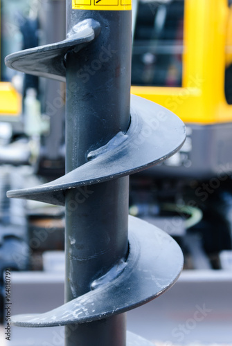 Large spiral cutter on a fence post drill, used by farmers to quickly erect fences. photo