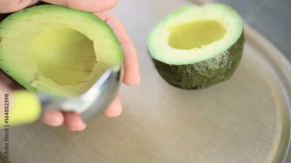 Slicing fresh avocado on a wood cutting board