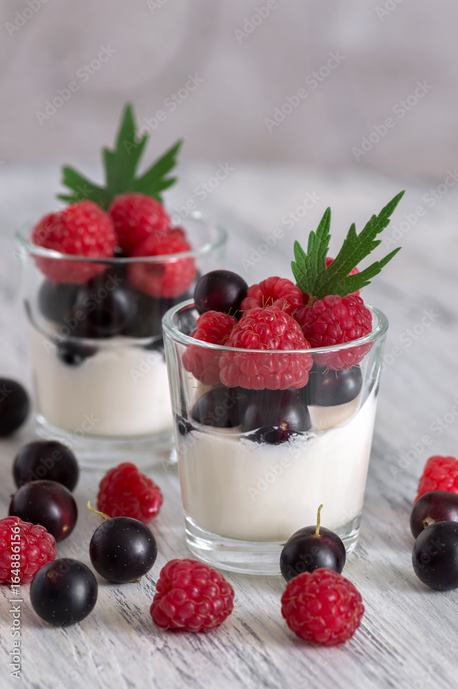 Delicate yogurt in glasses with raspberry and currant berries. Delicate yogurt in glasses with raspberry and currant berries.