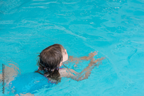 enfant nageant dans la piscine