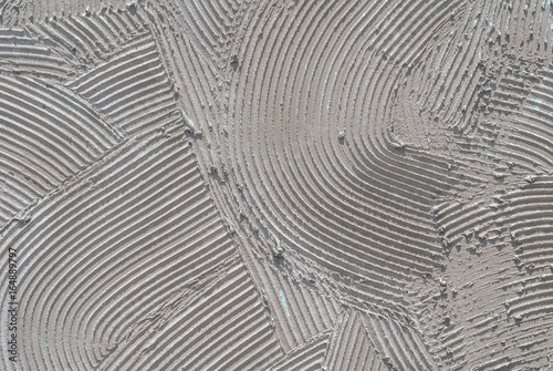 grey decorative relief plaster on wall closeup, background texture