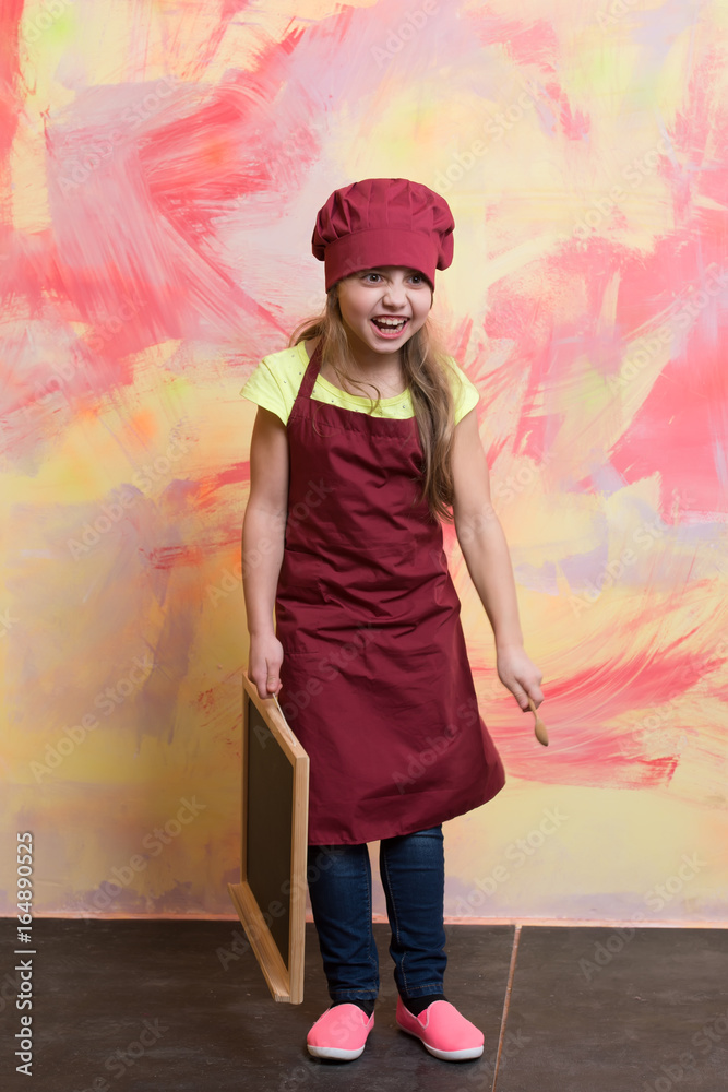 Chef child in apron on colorful background.