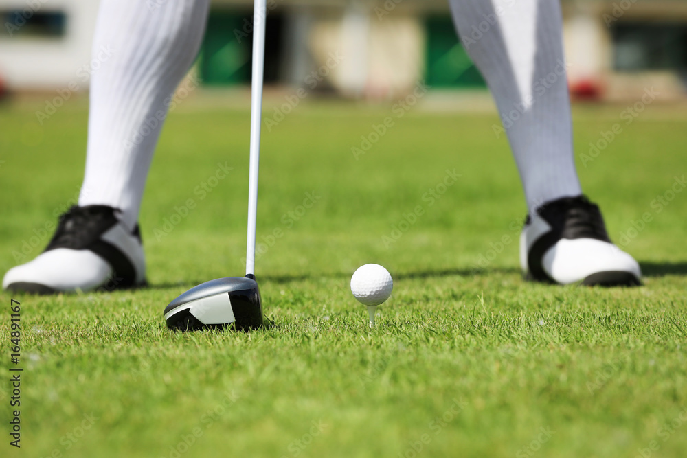 Obraz premium Legs of young man playing golf on course in sunny day
