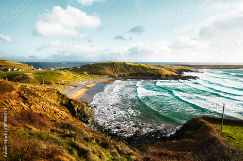 Beautiful Irish bay in Donegal with turquoise water and big waves clashing against the beach of a small village Muckross photo