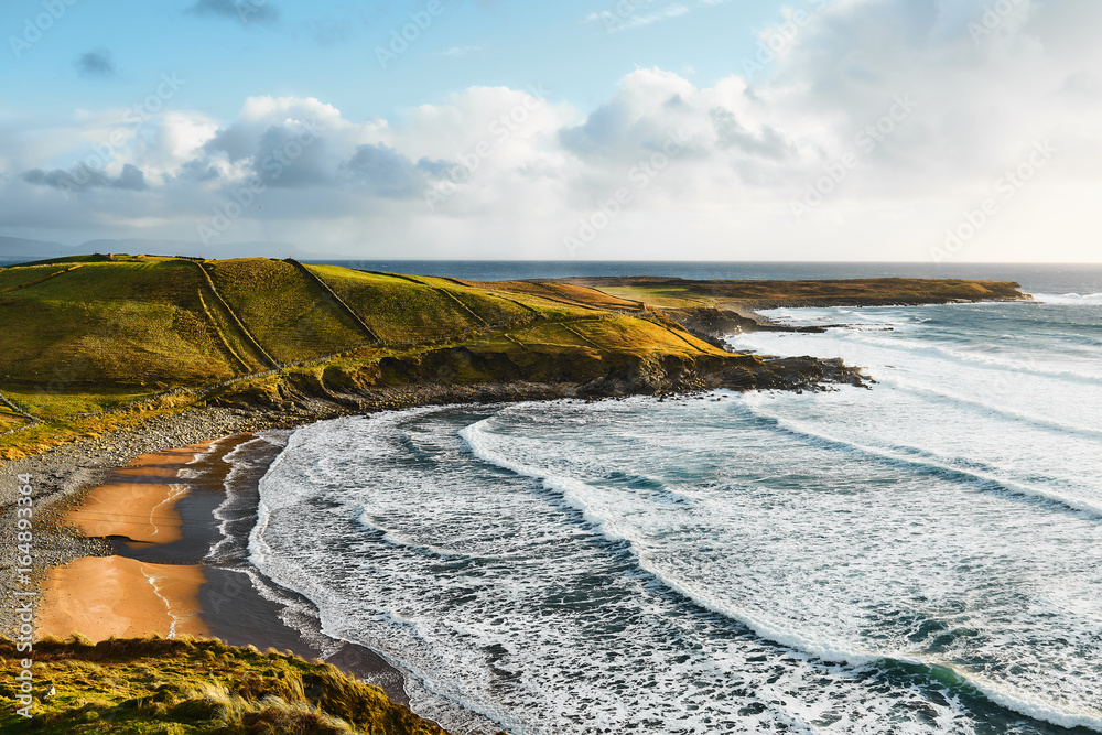 Fototapeta premium Küste und Strand in Donegal Irland mit grossen Wellen, Klippen und grüner Weide