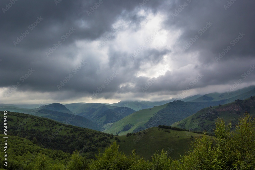 Горный пейзаж, облачное небо над живописным горным ущельем, пасмурная погода, дикая природа Северного Кавказа