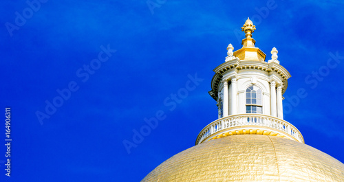 Golden dome of Massachusetts State House under blue sky