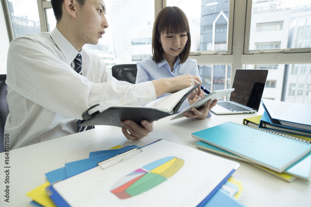 Fototapeta premium Young businessmen are checking the schedule by watching the notebook