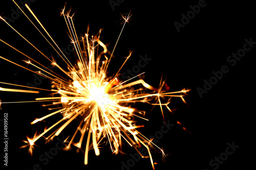 Sparklers background / A sparkler is a type of hand-held firework that burns slowly while emitting colored flames, sparks, and other effects