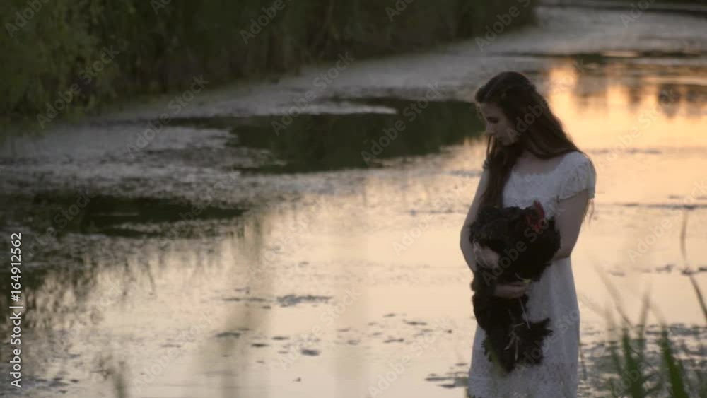 Thoughtful Brunette In White Dress Standing By The River In The Reeds With Cock On Hands In Time Of Sunset Thoughtful Brunette In White Dress Standing By The River In The Reeds With Cock On Hands In Time Of Sunset