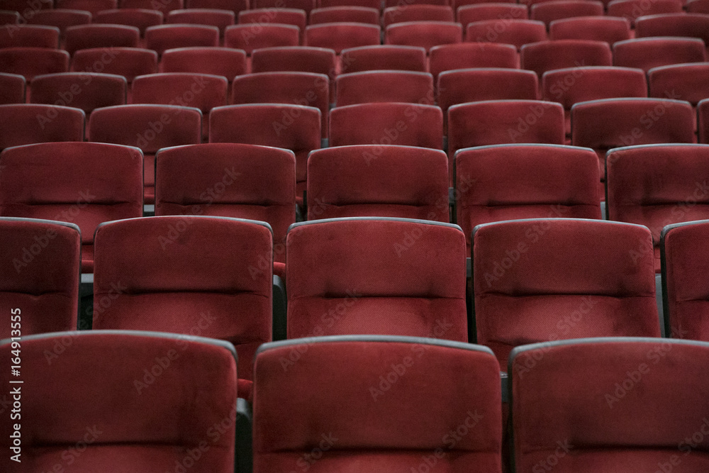 Obraz premium Empty cinema room with red chairs closeup