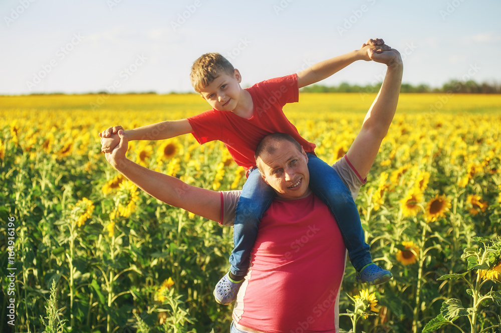 father with child in a field of blooming sunflowers , father's day father with child in a field of blooming sunflowers , father's day