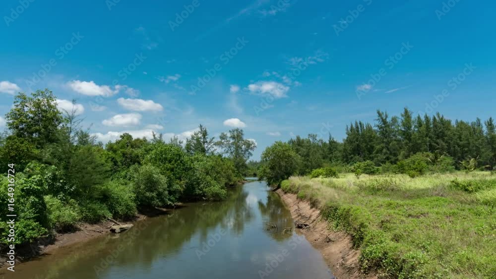4K-timelapse of canal with tropical forest, blue sky and clouds in phuket thailand 4K-timelapse of canal with tropical forest, blue sky and clouds in phuket thailand