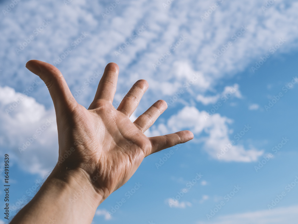 Hand of a man reaching to towards sky. Color toned image. Selective focus. Hand of a man reaching to towards sky. Color toned image. Selective focus.