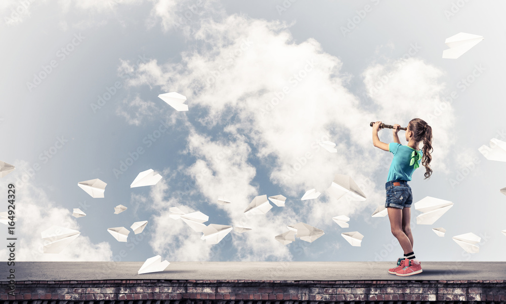 Concept of careless happy childhood with girl exploring this wor