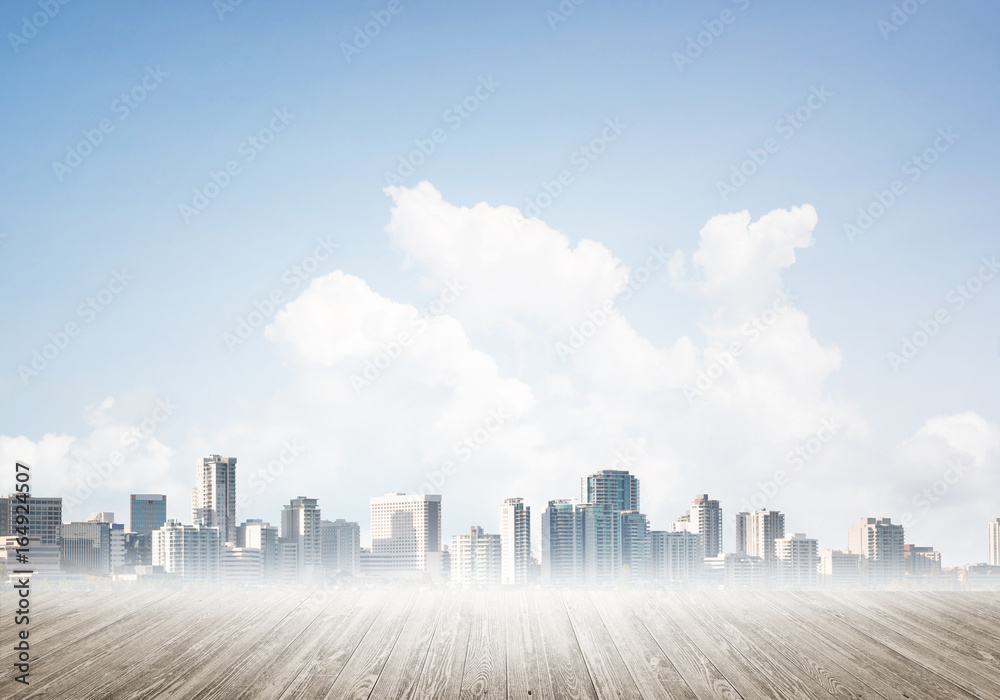 Modern urban buildings skyscrapers blue cloudy sky background and wooden textured platform
