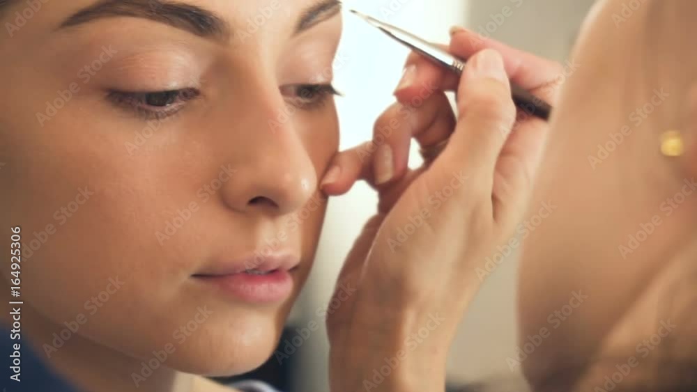 Young beautiful woman applying make-up by make-up artist Young beautiful woman applying make-up by make-up artist
