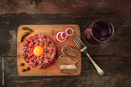 Steak tartare with garnish, red wine, and copyspace