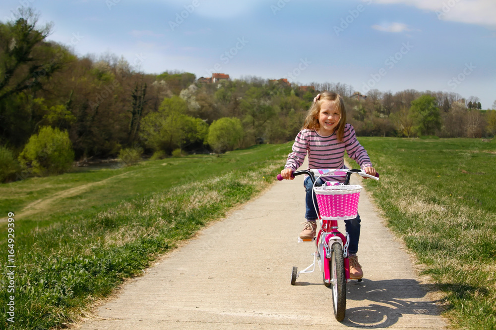 cute little girl riding bicycle outdoor