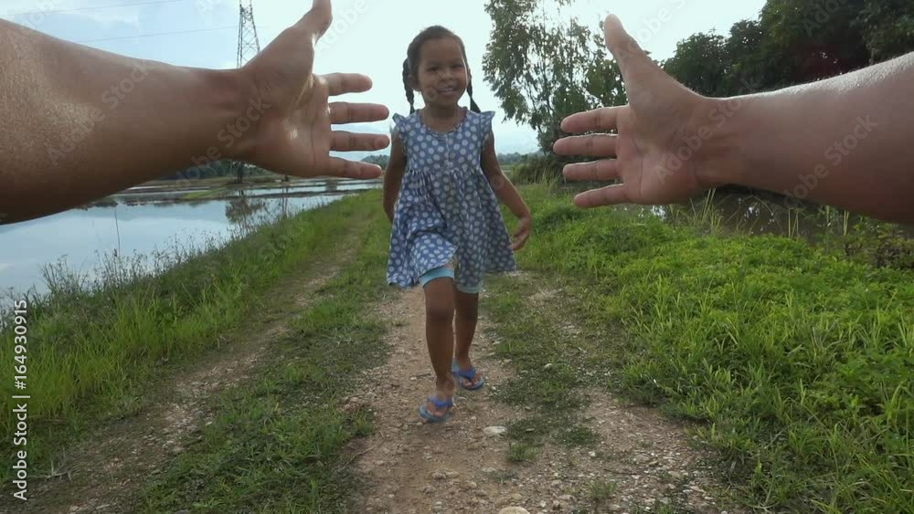 Point of view slow motion shot of father spinning his daughter around in field