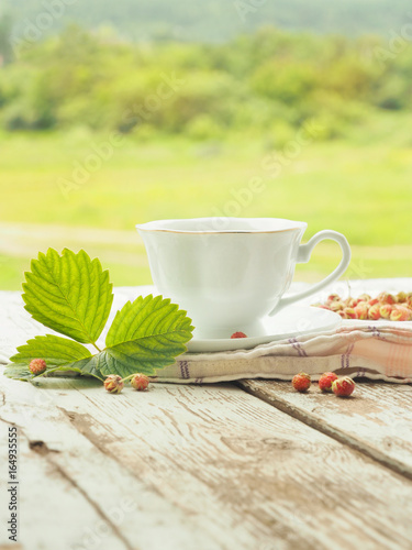 White cup of tea on a wooden table