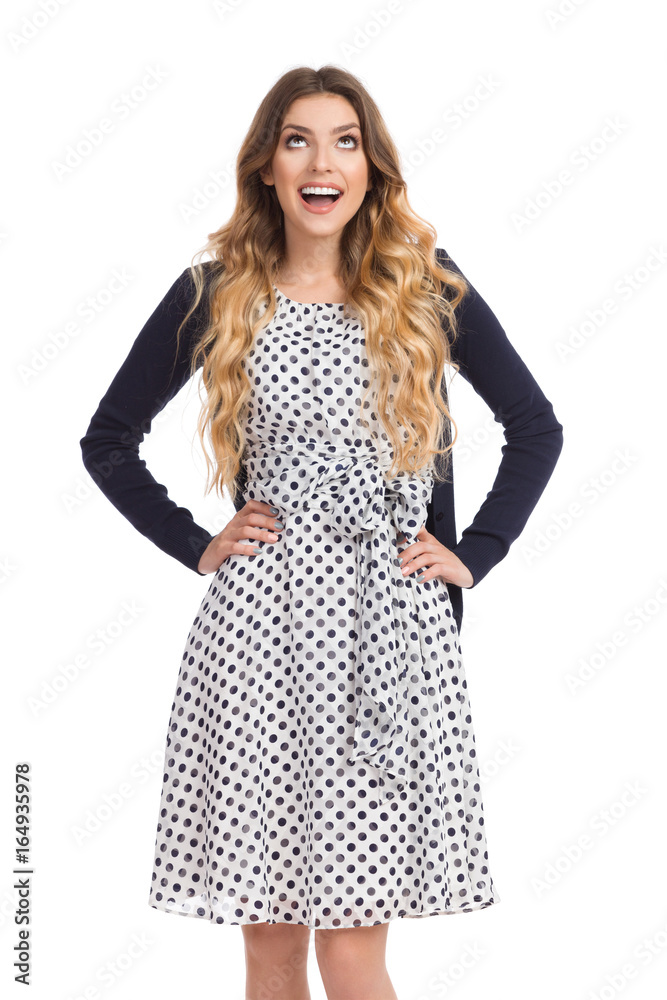 Smiling Young Woman In White Dotted Dress And Cardigan Is Looking Up Smiling Young Woman In White Dotted Dress And Cardigan Is Looking Up