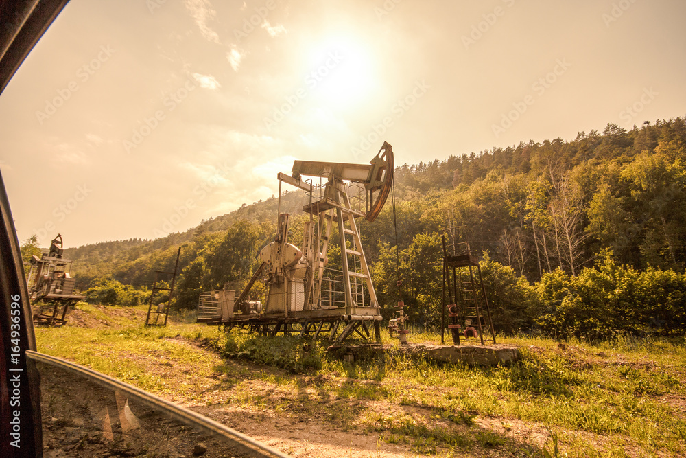 oil pump near a forest, visible from the window of a passing car oil pump near a forest, visible from the window of a passing car