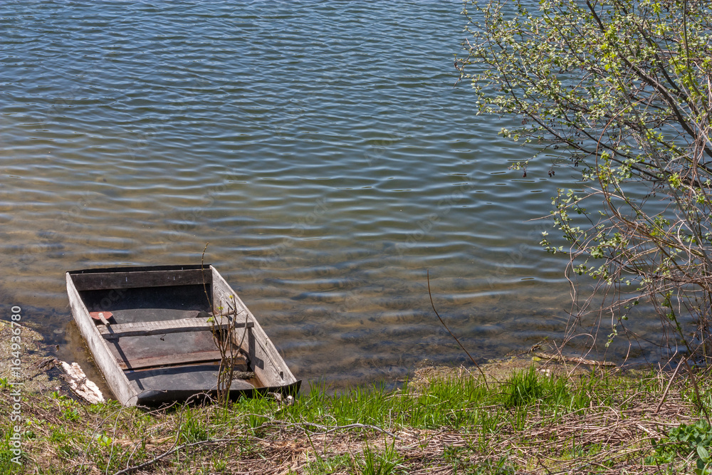 Old wooden boat moored to the bank of the lake Old wooden boat moored to the bank of the lake