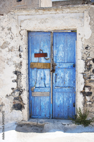Bright blue old weathered door on the island of Santorini, Greece, Europe.