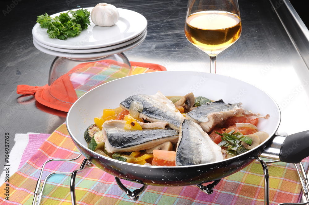 Fillet of sea bass with vegetables in a pan