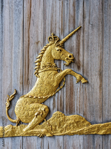Gold colored Unicorn relief on a wooden door – Scotland’s National Animal